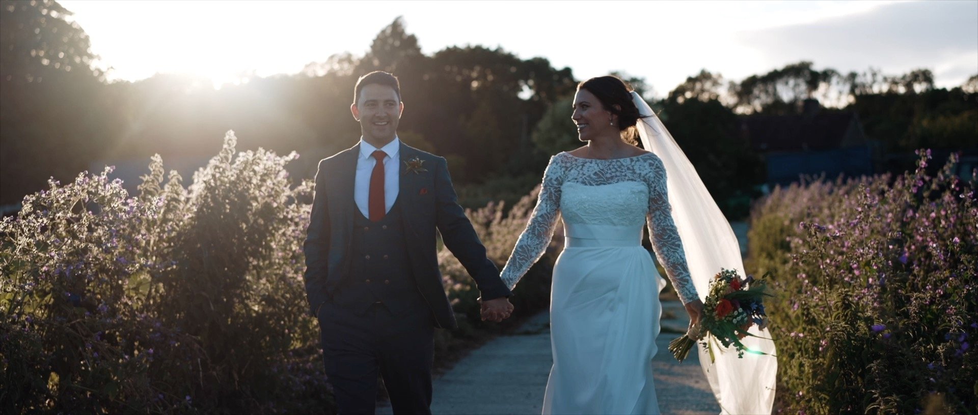 Happy wedding couple holding hands. Bride in white dress, groom in suit. Outdoor wedding photography.