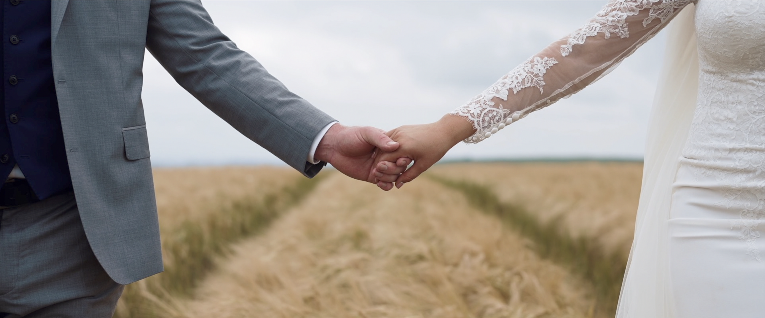 Bride and groom holding hands in wheat field. Wedding photography, marriage concept.