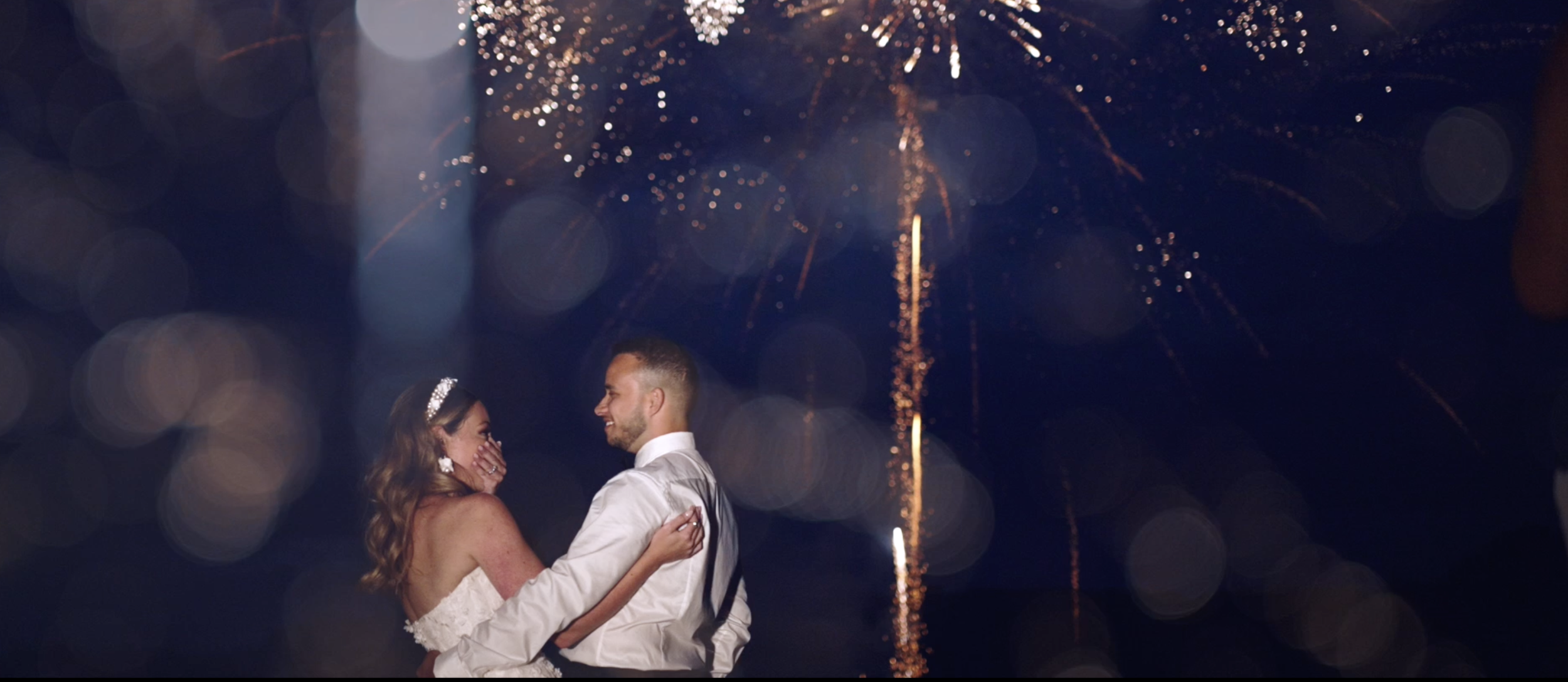 Bride and groom watch wedding fireworks. Happy couple celebrating marriage with fireworks display.