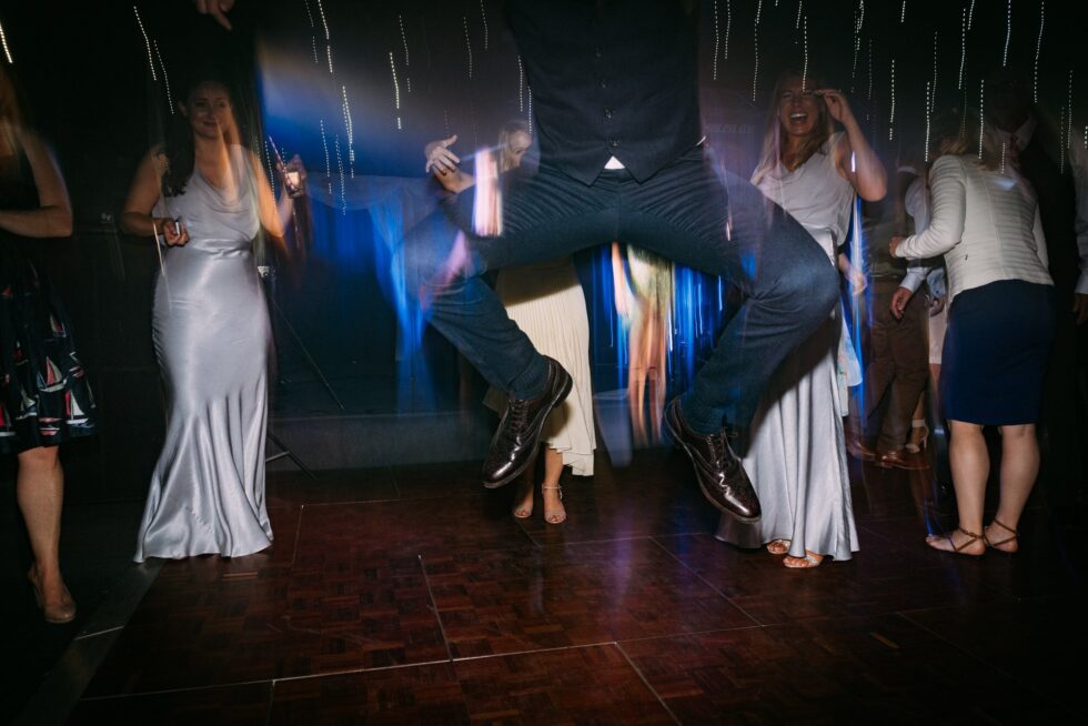 Devon wedding party dancing. Guests celebrate with a jump on the dance floor. Yeti Wedding Photography.