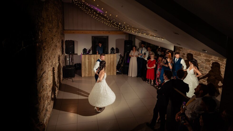 First dance at Trevenna Barns wedding in Cornwall. Bride and groom dancing, guests watching. Yeti Wedding Photography.