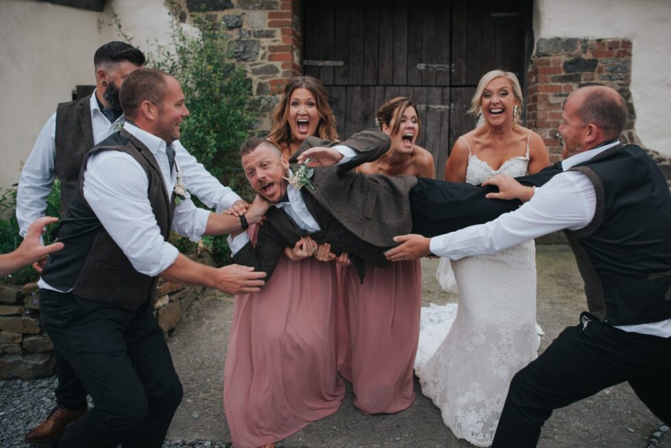 Groom lifted by groomsmen & bridesmaids at Higher Eggbeer Devon wedding. Fun wedding photography.