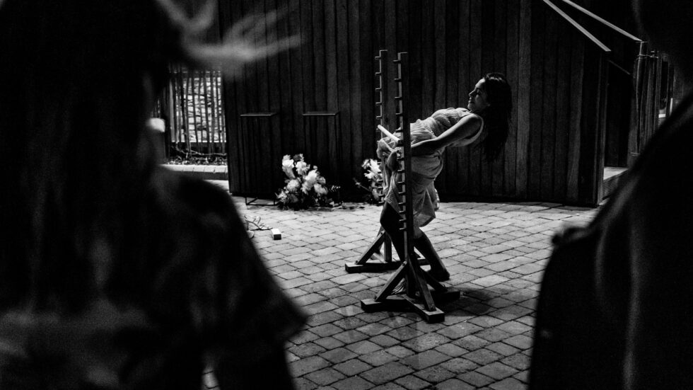 Black and white wedding photo of a woman doing the limbo. Yeti Wedding Photography.
