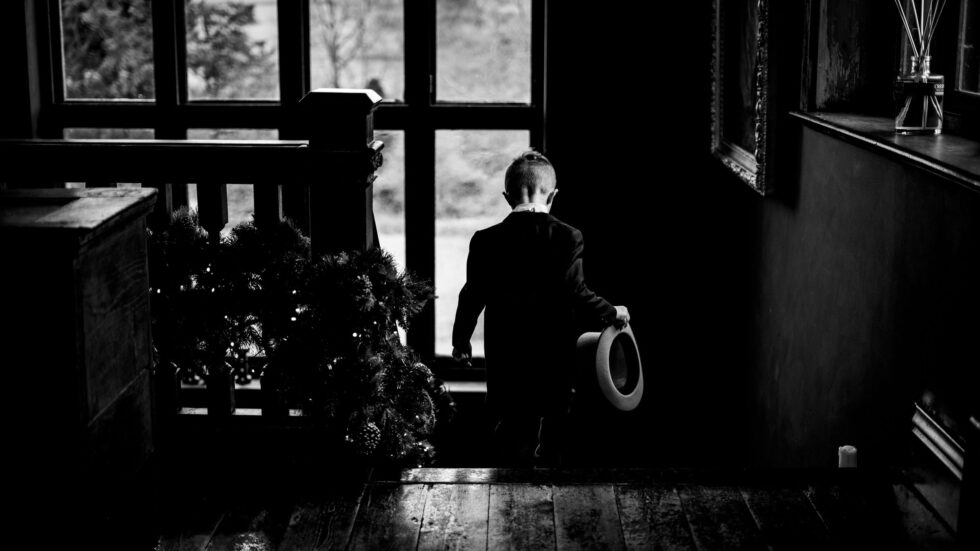 Black and white wedding photography of pageboy in top hat at Huntsmacourt, Devon.