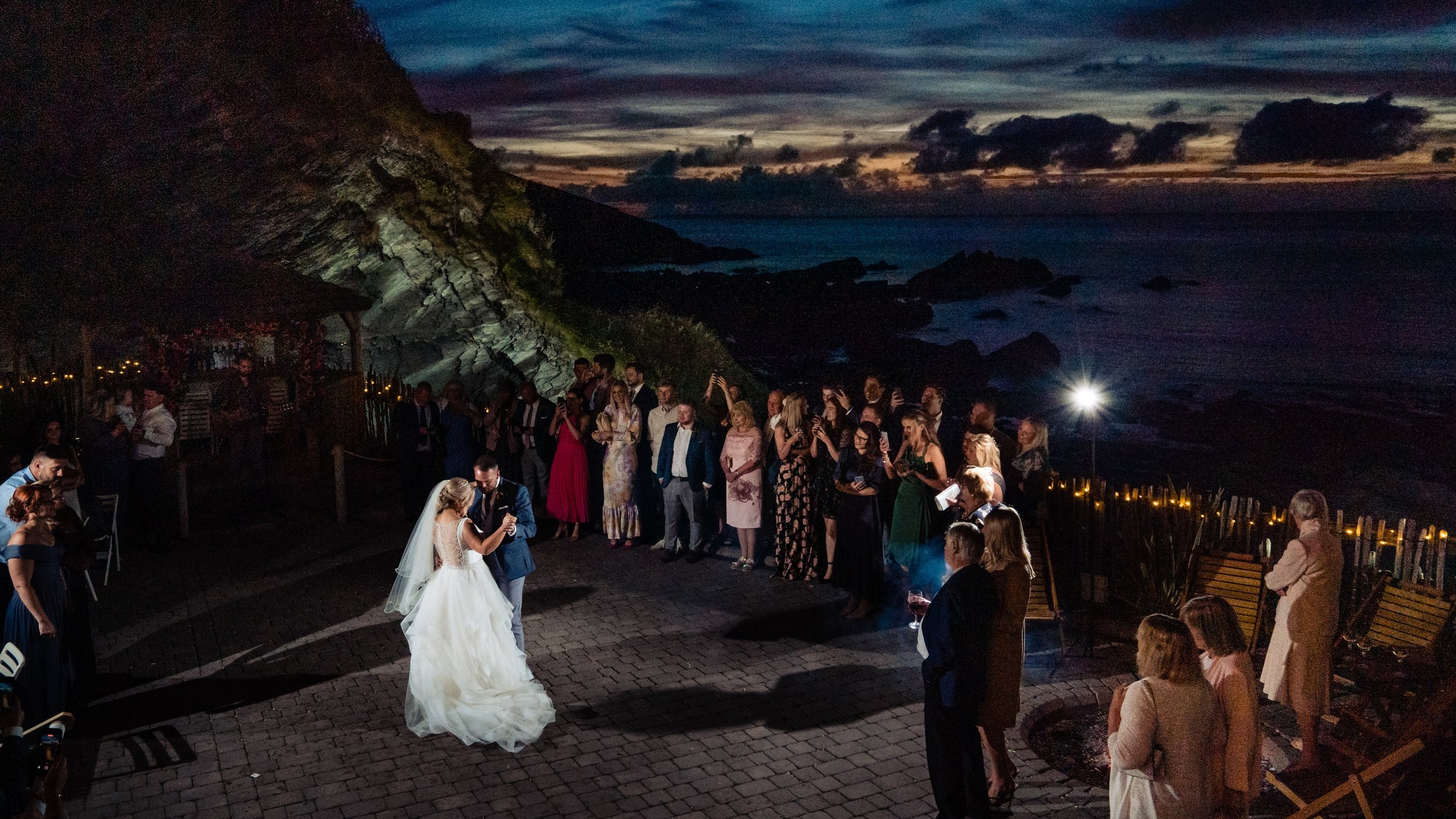 tunnels beaches first dance outside with bride, groom and wedding guests