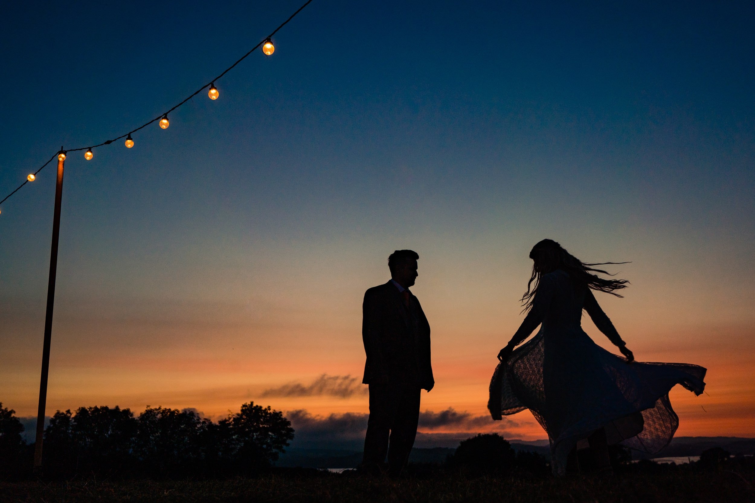 sunset wedding photo devon dress twirling and festoons bride and groom